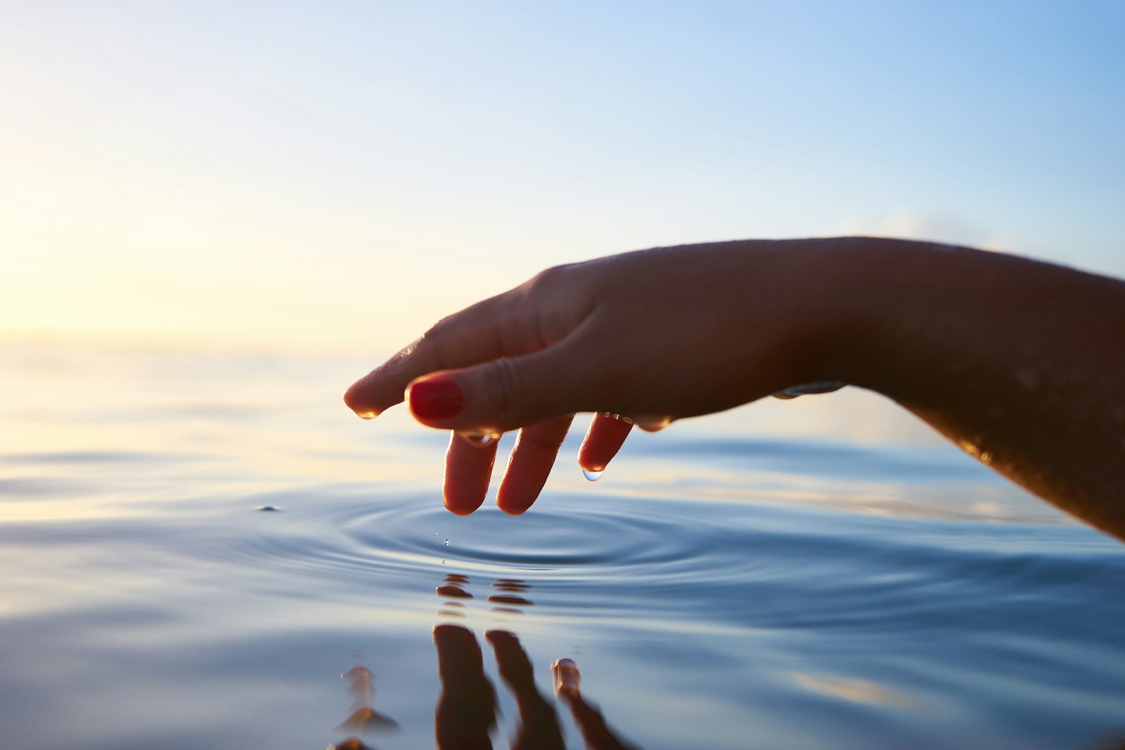 Photo by Yoann Boyer person about to touch the calm water