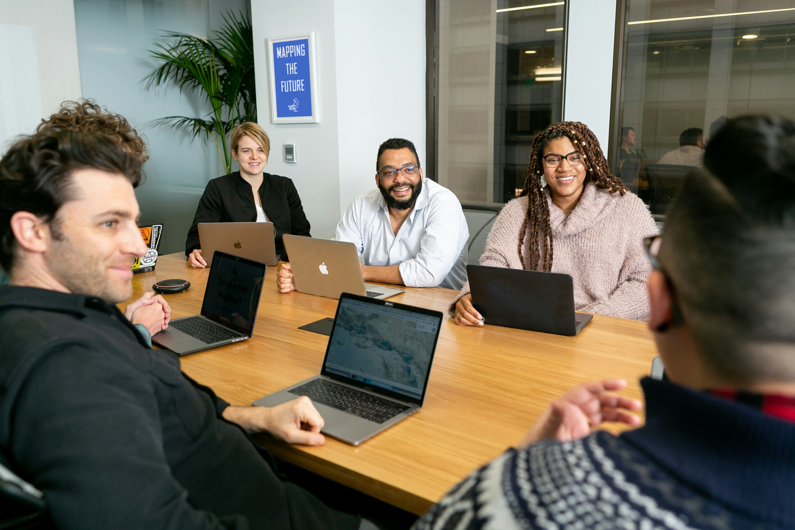 Join-Futurise-2 four people all on laptops, two men and two women, listen to person talking in a board meeting
